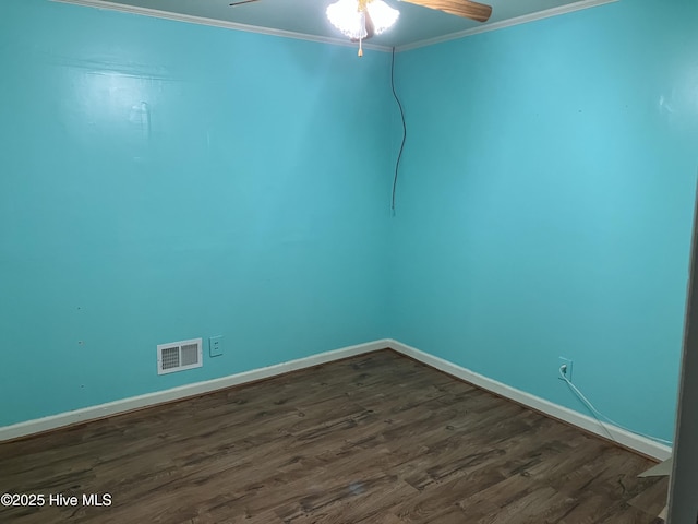 empty room with crown molding, dark wood-type flooring, ceiling fan, and baseboards