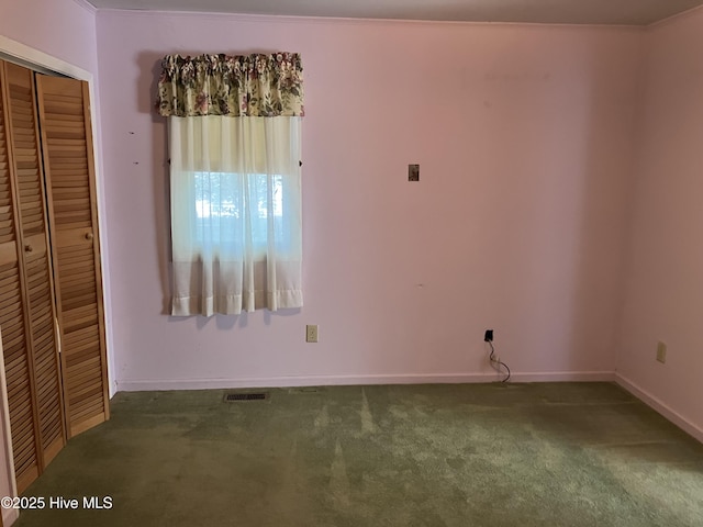 unfurnished room featuring carpet floors and baseboards