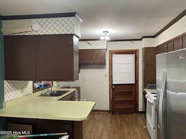 kitchen with freestanding refrigerator, a sink, wallpapered walls, white range with electric stovetop, and dark wood-style floors