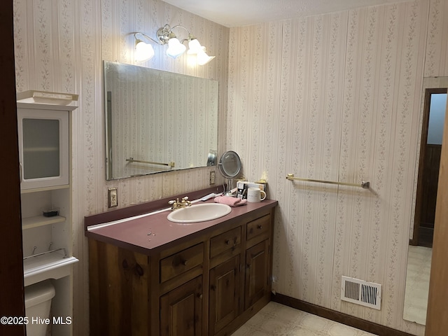 bathroom with toilet, vanity, and a chandelier