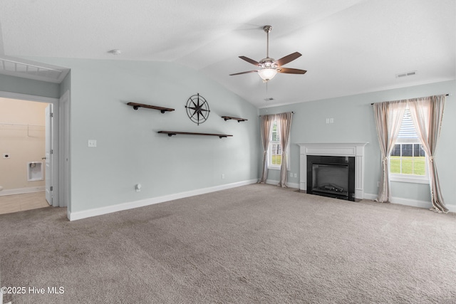 unfurnished living room featuring a healthy amount of sunlight, a ceiling fan, visible vents, carpet floors, and lofted ceiling