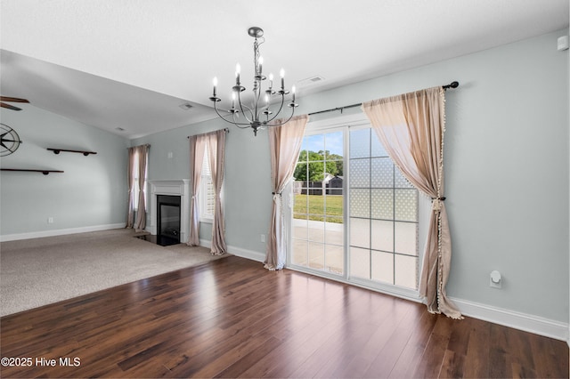 unfurnished living room with baseboards, a fireplace with flush hearth, wood finished floors, and visible vents