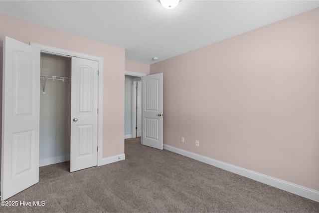 unfurnished bedroom featuring baseboards, carpet, and a closet