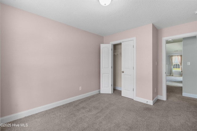 unfurnished bedroom featuring carpet floors, baseboards, and a closet