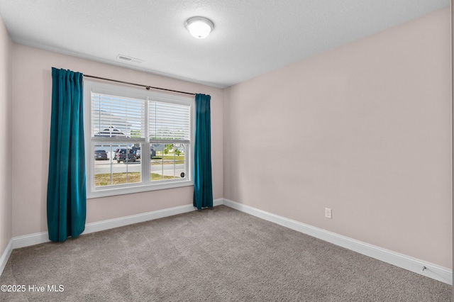 carpeted empty room with baseboards and visible vents