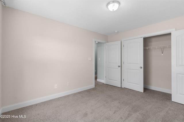 unfurnished bedroom with carpet floors, baseboards, and a closet