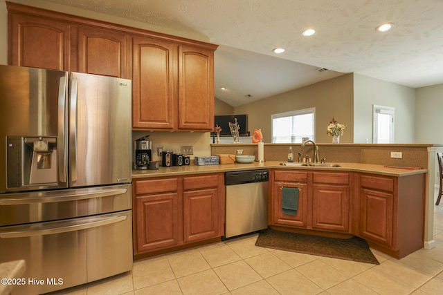 kitchen with a peninsula, a sink, light tile patterned flooring, recessed lighting, and appliances with stainless steel finishes