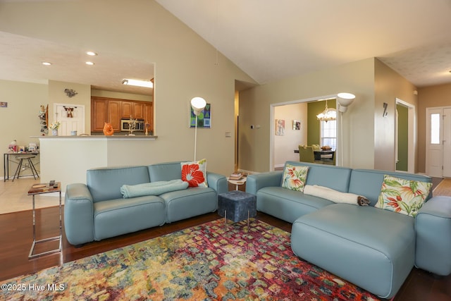 living area with vaulted ceiling, wood finished floors, recessed lighting, and a notable chandelier
