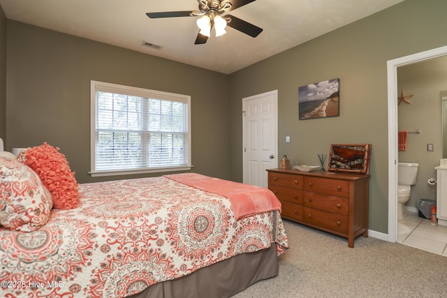 carpeted bedroom with baseboards, a ceiling fan, ensuite bathroom, and visible vents