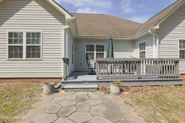 back of house with roof with shingles and a deck