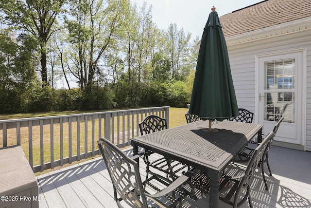 deck featuring a lawn and outdoor dining space