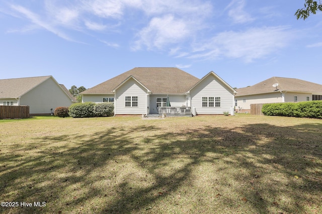 rear view of property with fence and a yard
