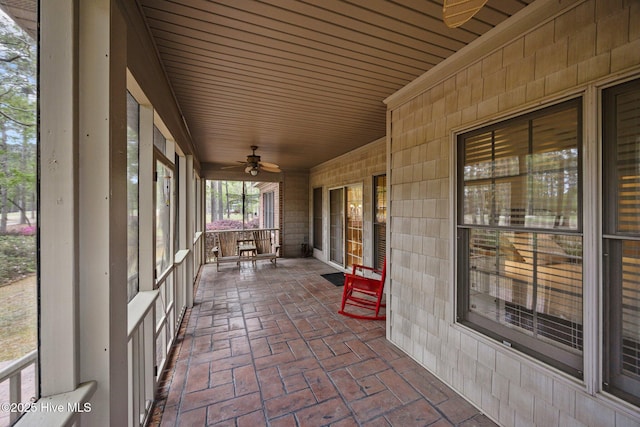 unfurnished sunroom with a ceiling fan