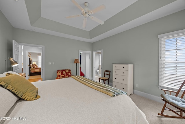 bedroom featuring a raised ceiling, carpet flooring, and baseboards
