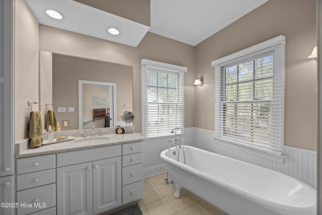 full bathroom featuring a wainscoted wall, a freestanding tub, tile patterned flooring, and vanity