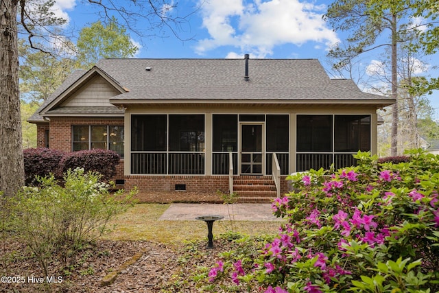 rear view of property featuring crawl space, a sunroom, and a shingled roof