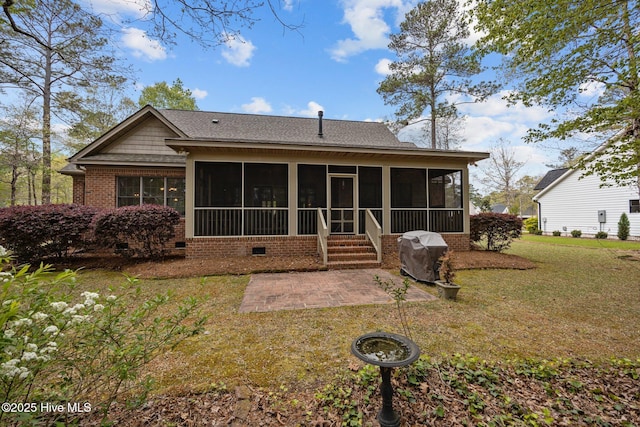 back of property with a patio area, a shingled roof, a sunroom, and a yard