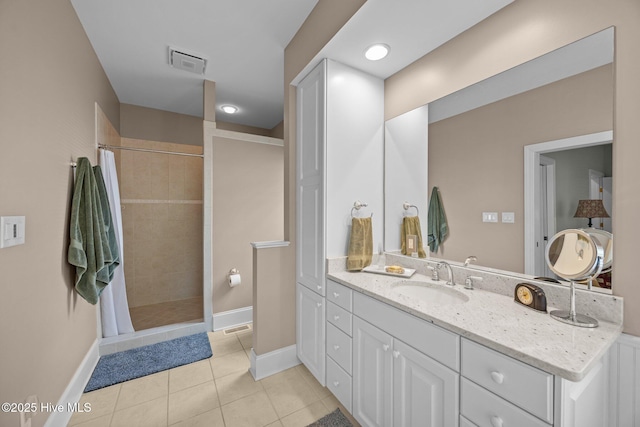 full bath with a tile shower, baseboards, visible vents, tile patterned flooring, and vanity