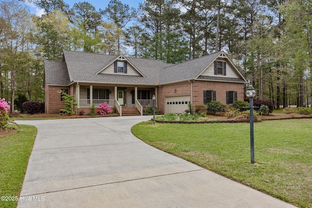 craftsman-style home with brick siding, driveway, a porch, and a front lawn