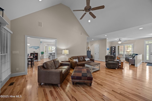 living area featuring light wood-type flooring, visible vents, recessed lighting, ceiling fan, and high vaulted ceiling