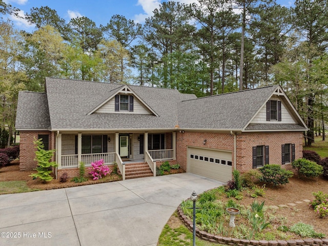 craftsman inspired home with brick siding, driveway, a garage, and covered porch
