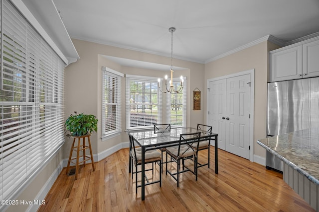 dining area featuring light wood-type flooring, baseboards, a chandelier, and crown molding