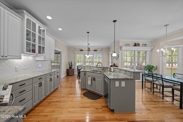kitchen with a chandelier, gray cabinetry, a sink, and light wood-style floors
