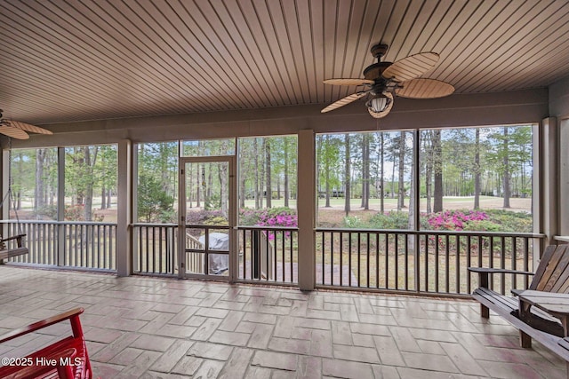 unfurnished sunroom with a ceiling fan and wooden ceiling