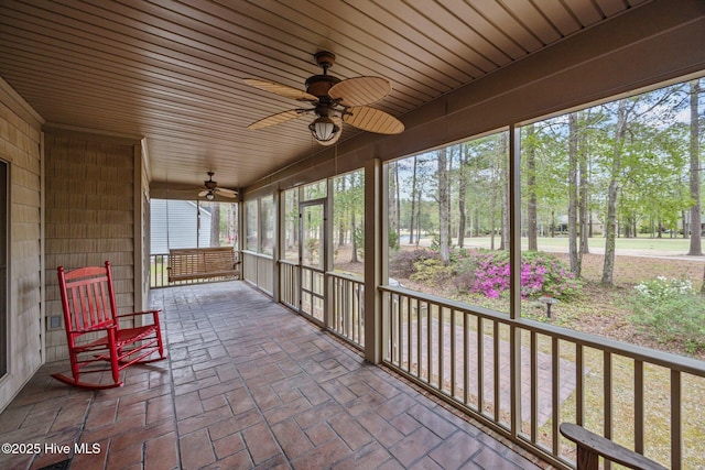 unfurnished sunroom with ceiling fan