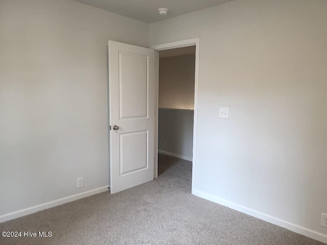 460 Maides Ave, Wilmington, NC 28405 - unfurnished bedroom featuring a walk in closet, carpet, and baseboards