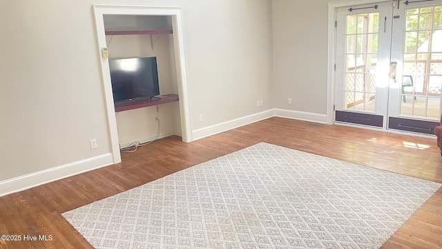 3772 Old Maco Rd NE, Leland, NC 28451 - unfurnished living room with baseboards, french doors, and wood finished floors