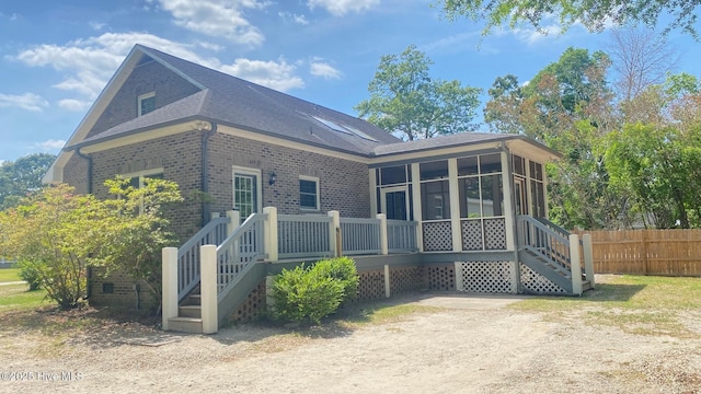 3772 Old Maco Rd NE, Leland, NC 28451 - rear view of house featuring a sunroom, stairway, brick siding, fence, and a shingled roof