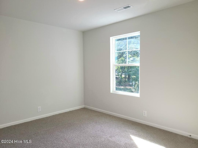 unfurnished room with baseboards, visible vents, and carpet floors