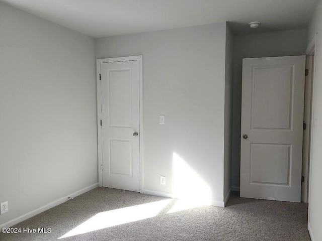 carpeted empty room with baseboards