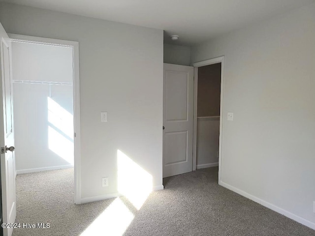 unfurnished bedroom with a closet, baseboards, and carpet