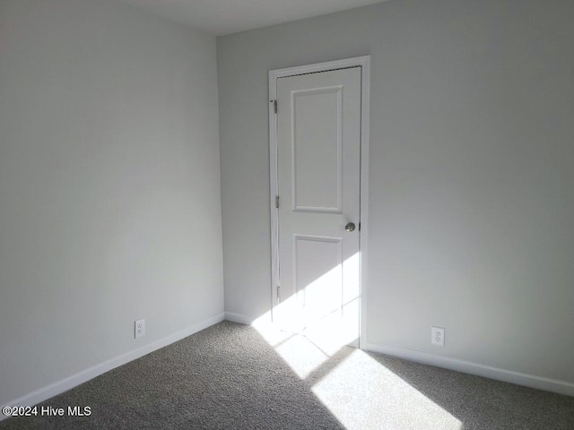 empty room with carpet and baseboards