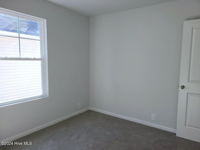 carpeted empty room featuring baseboards