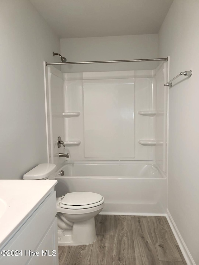 full bathroom with toilet, wood finished floors, vanity, and shower / washtub combination