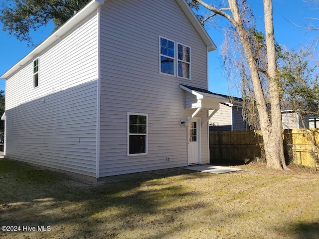 rear view of property with a yard and fence