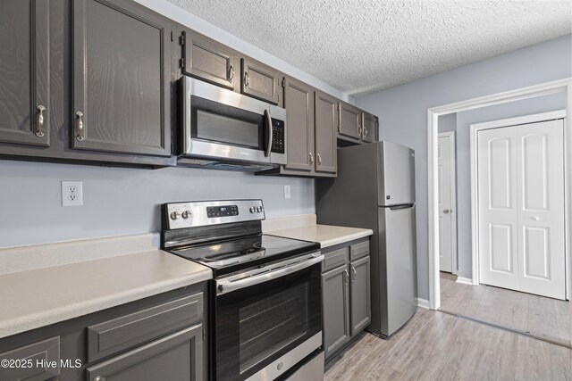 110 Vauhan Ct, Jacksonville, NC 28540 - kitchen featuring appliances with stainless steel finishes, a textured ceiling, light wood-type flooring, and light countertops