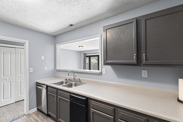110 Vauhan Ct, Jacksonville, NC 28540 - kitchen featuring light wood finished floors, light countertops, a sink, a textured ceiling, and dishwasher
