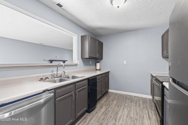 110 Vauhan Ct, Jacksonville, NC 28540 - kitchen with a textured ceiling, a sink, light wood-type flooring, stainless steel appliances, and visible vents