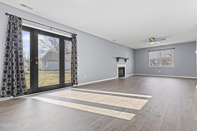 110 Vauhan Ct, Jacksonville, NC 28540 - unfurnished living room featuring hardwood / wood-style floors, a fireplace with flush hearth, ceiling fan, baseboards, and visible vents
