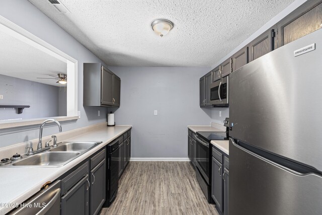 110 Vauhan Ct, Jacksonville, NC 28540 - kitchen featuring a sink, a textured ceiling, light wood-style floors, light countertops, and black appliances