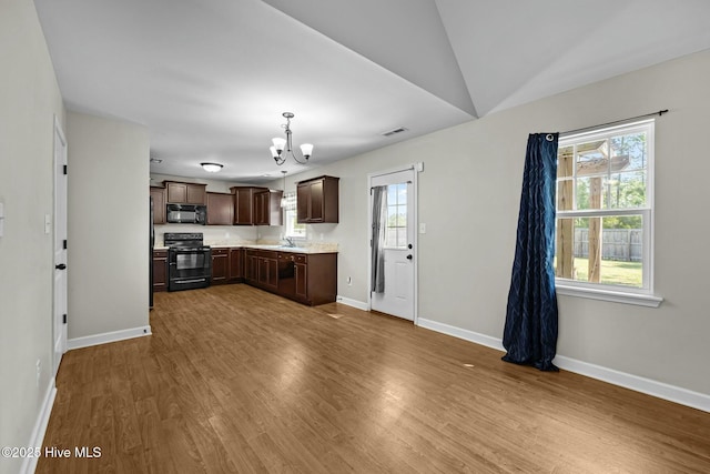 500 Maggies Ct, Jacksonville, NC 28540 - kitchen featuring light countertops, wood finished floors, dark brown cabinetry, black appliances, and a notable chandelier