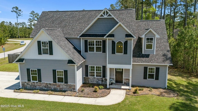 500 Maggies Ct, Jacksonville, NC 28540 - view of front of house with stone siding, a shingled roof, a front lawn, and a porch