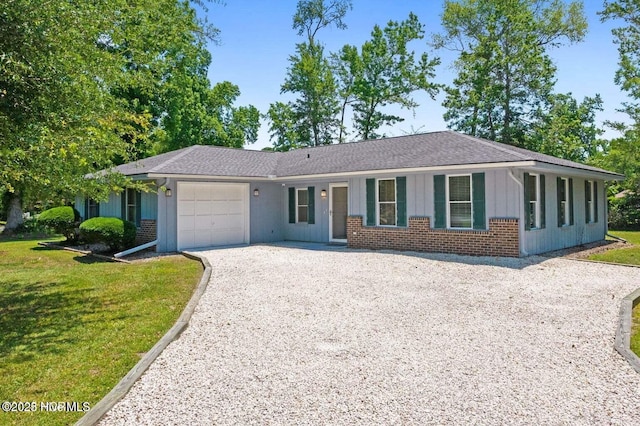 1 Pelican Ct, Carolina Shores, NC 28467 - ranch-style home featuring board and batten siding, gravel driveway, brick siding, a front lawn, and a garage