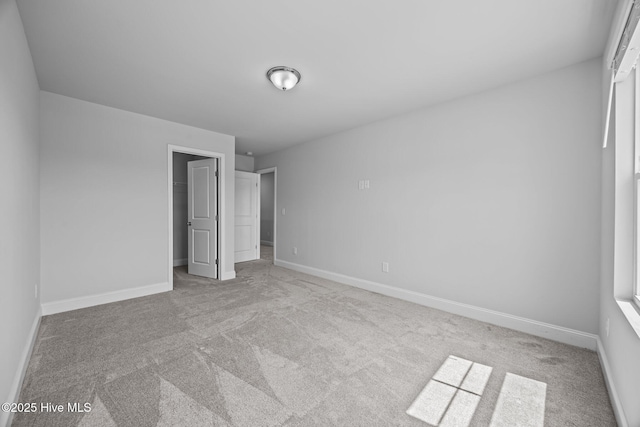 260 E Red Head Cir, Sneads Ferry, NC 28460 - unfurnished bedroom featuring a walk in closet, carpet flooring, and baseboards