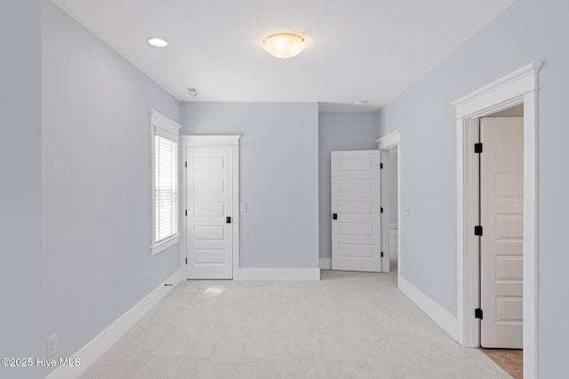 additional living space with recessed lighting, baseboards, light colored carpet, and a sink
