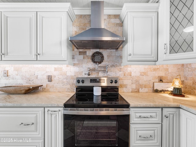 433 Dion Dr, Hubert, NC 28539 - kitchen featuring stainless steel range with electric stovetop, wall chimney exhaust hood, white cabinets, light countertops, and backsplash